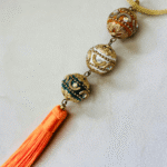 Collar largo con 3 esferas de arcilla polimérica en colores sutiles, con incrustaciones de pewter y cristal y terminado en cinta metálica dorada. - Image 2