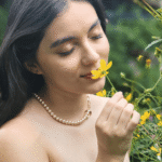 Exquisito collar asimétrico de perlas de cristal color durazno. Cadena dorada, baño de oro 18k.