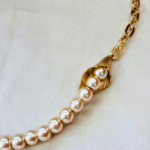 Exquisito collar asimétrico de perlas de cristal color durazno. Cadena dorada, baño de oro 18k. - Image 2