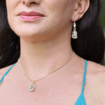 Delicadísimo juego de collar y aretes dorado, aleación de metales, con cristal verde.