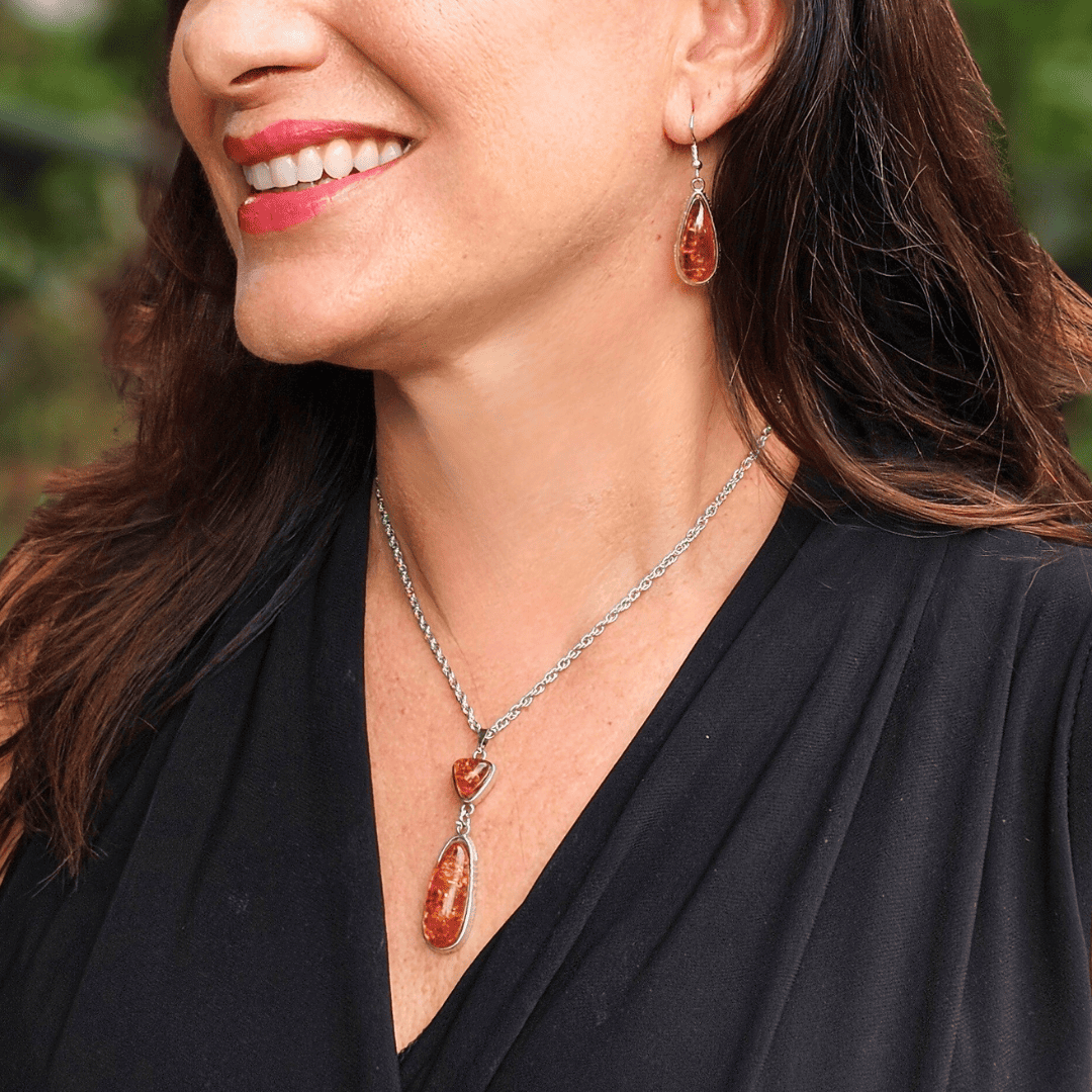 CI-2000E Armónico juego de aretes y cadena plateada, con dijes de resina color ámbar. - Image 1