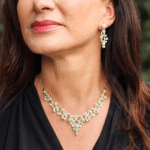 Distinguido juego de collar y aretes dorados, aleación de zinc, perla acrílica, y brillantes sintéticos.